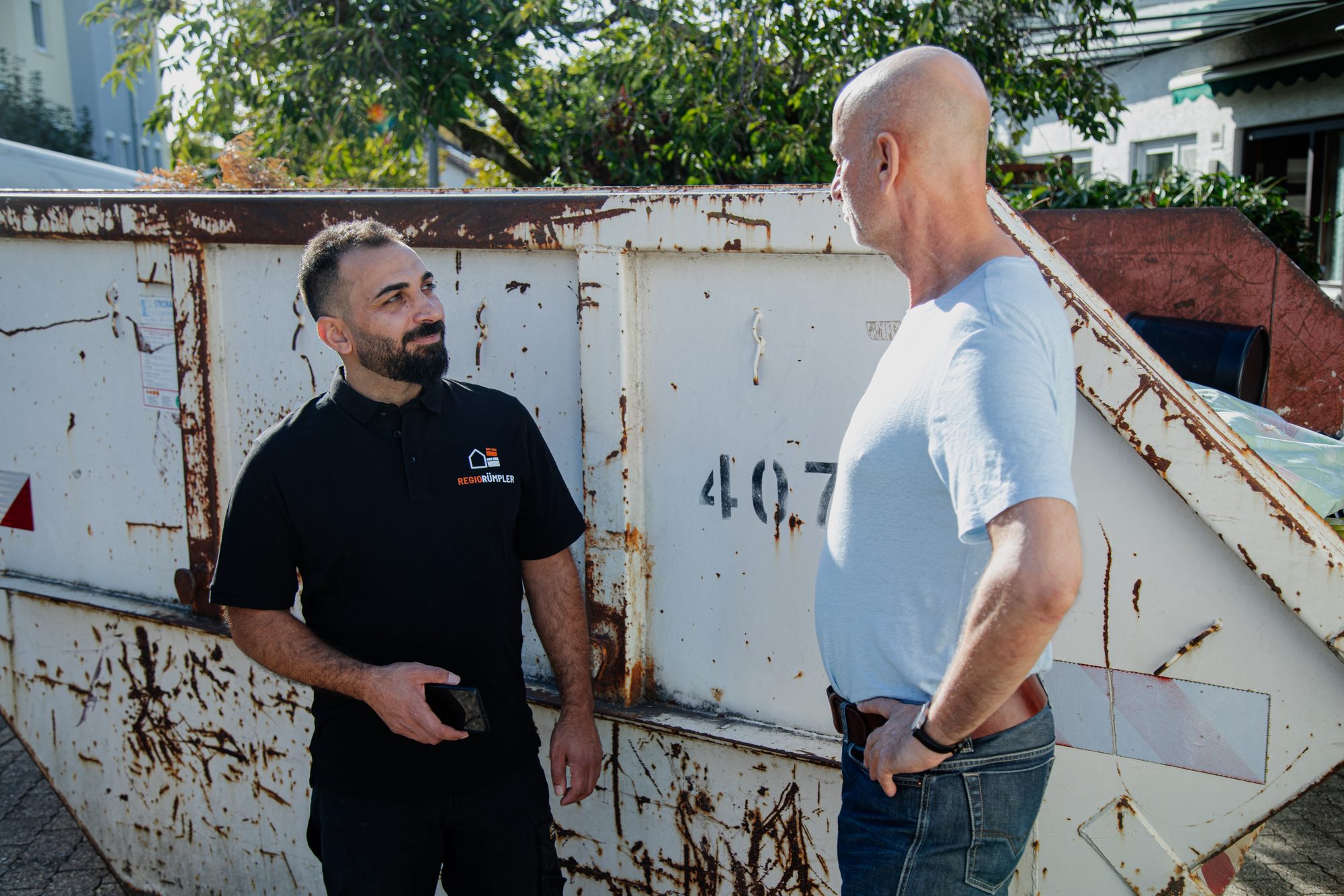 Der Inhaber von RegioRümpler und ein Kunde im Gespräch am Container.
