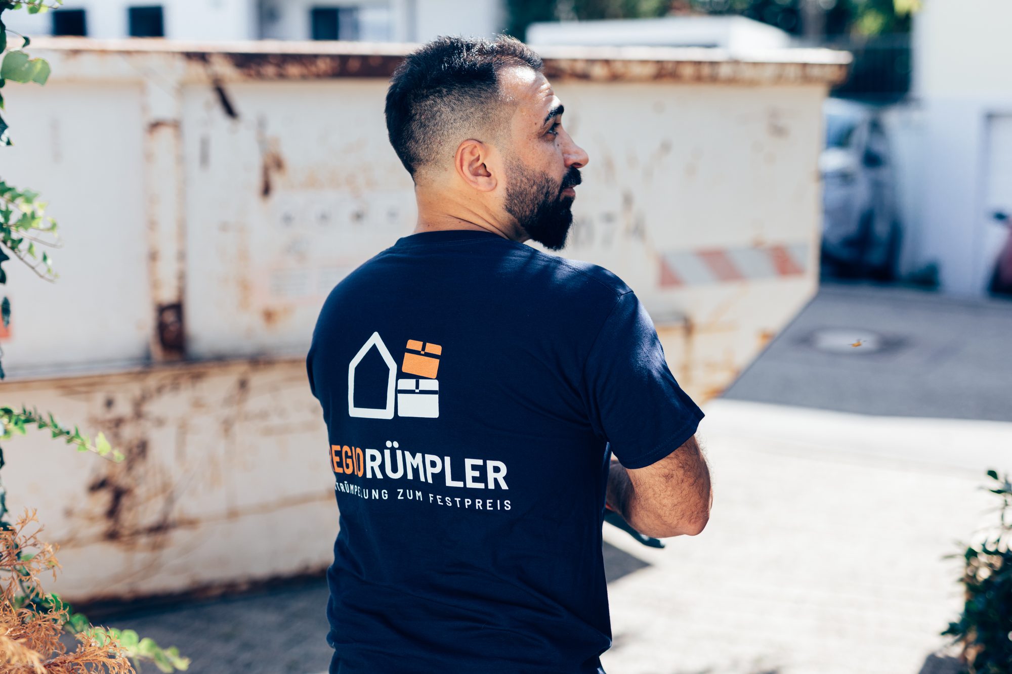 Ein Mitarbeiter von RegioRümpler am Container, in dem der Sperrmüll zur Entsorgung gesammelt wird.