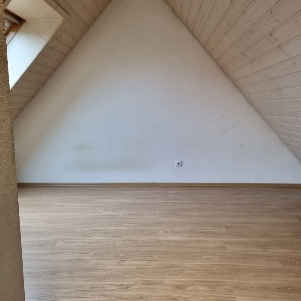Leerer Dachboden mit freiem Holzboden nach der besenreinen Übergabe.