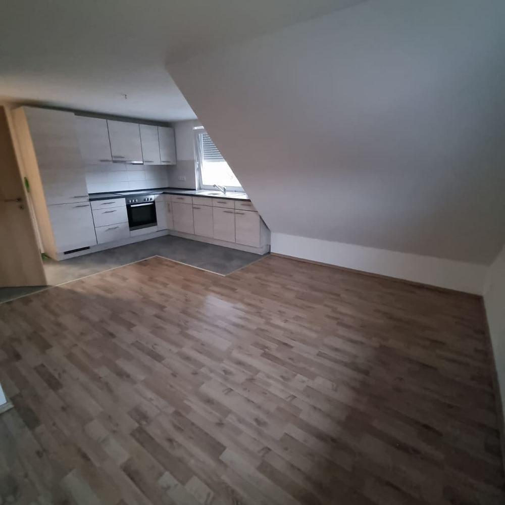 Leere Dachgeschosswohnung mit Einbauküche nach der besenreinen Übergabe.