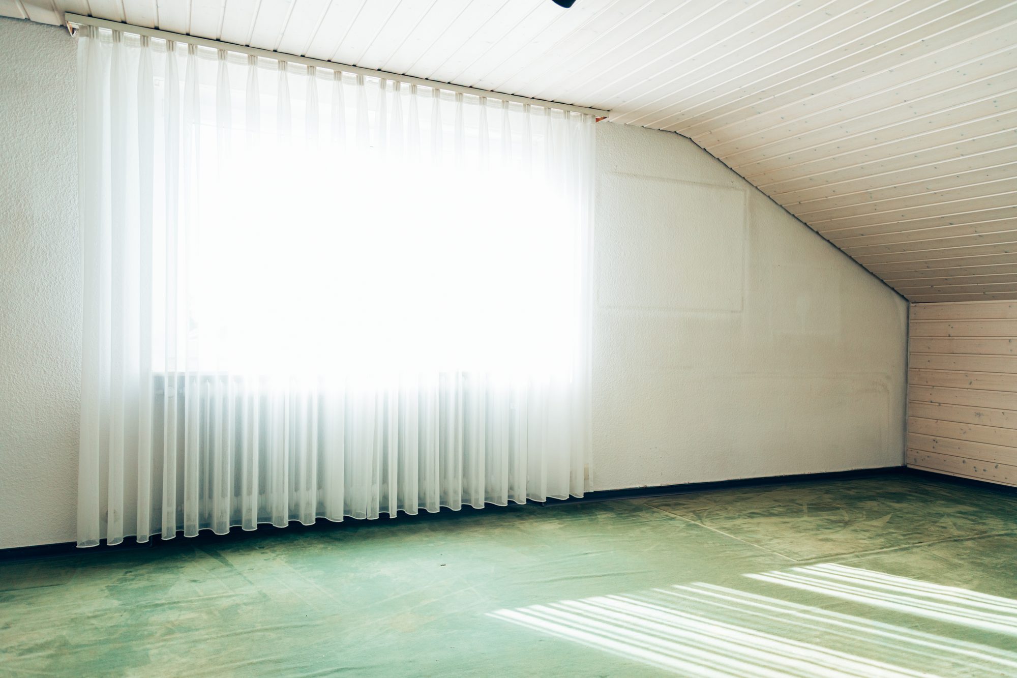 Leeres, besenreines Dachzimmer nach Räumung und Reinigung, bereit für die Übergabe.