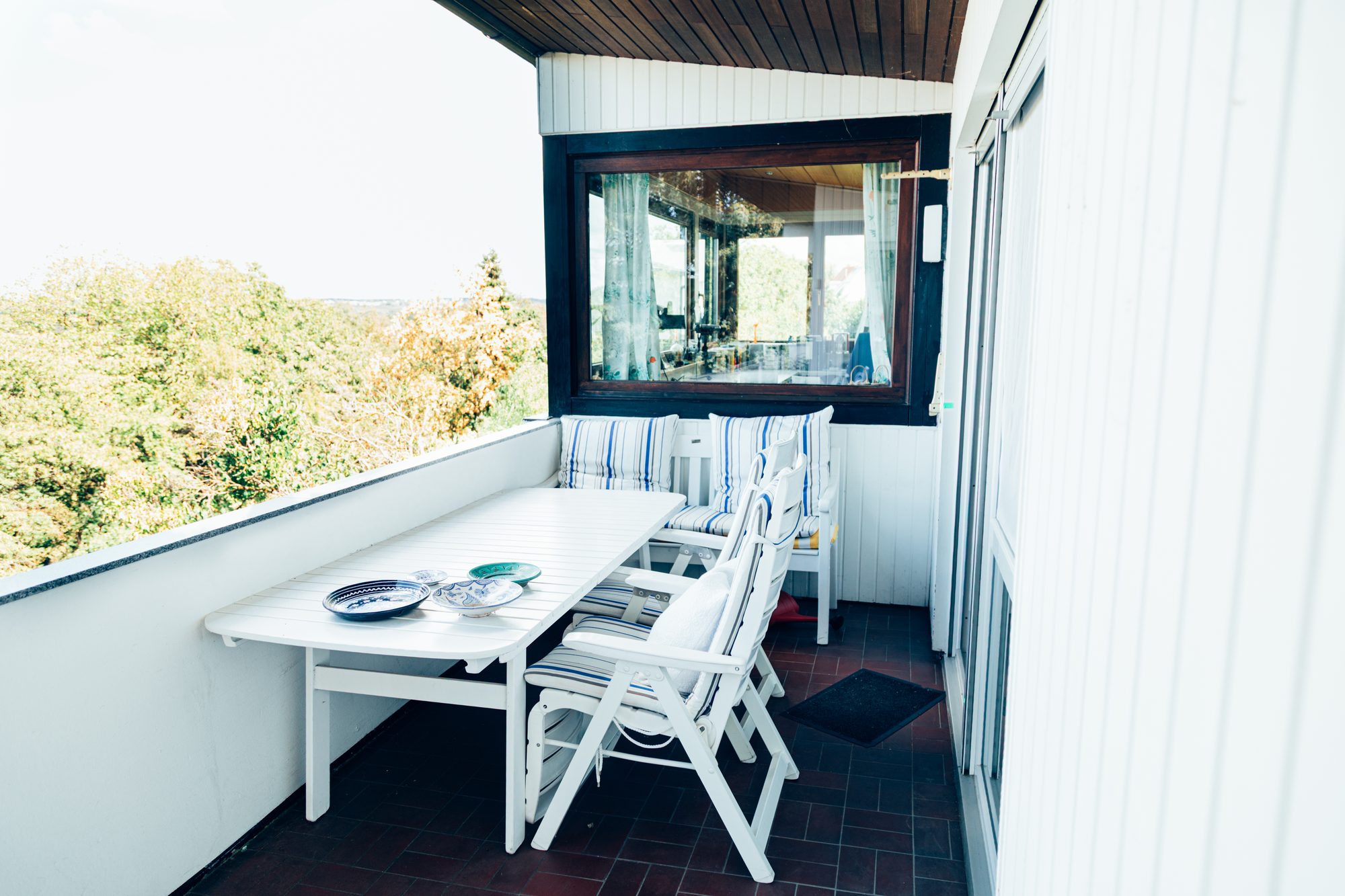 Überdachter Balkon mit Gartenmöbeln vor der Wohnungsentrümpelung.